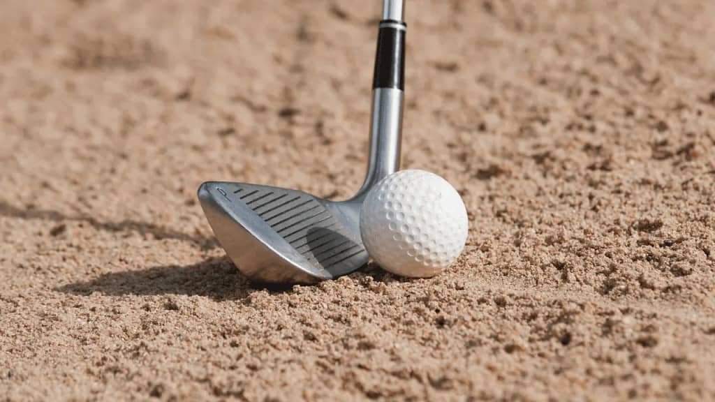 a sand wedge preparing for shot of a golf ball in bunker