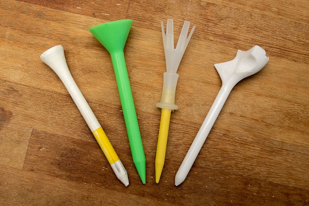 An image of different types of golf tees in a wooden background